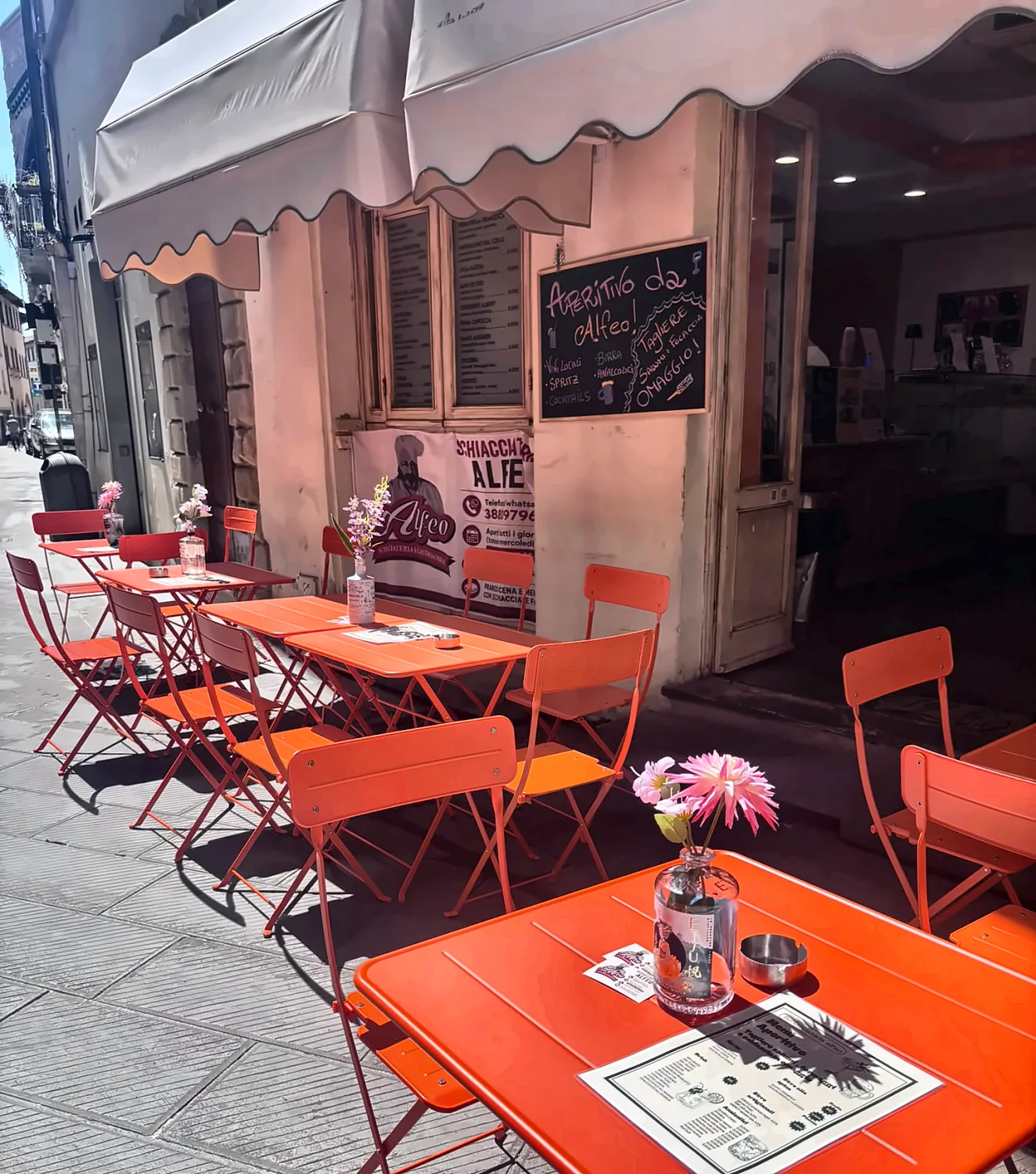 I tavolini arancioni all'aperto sotto la tenda, in Via XX Settembre